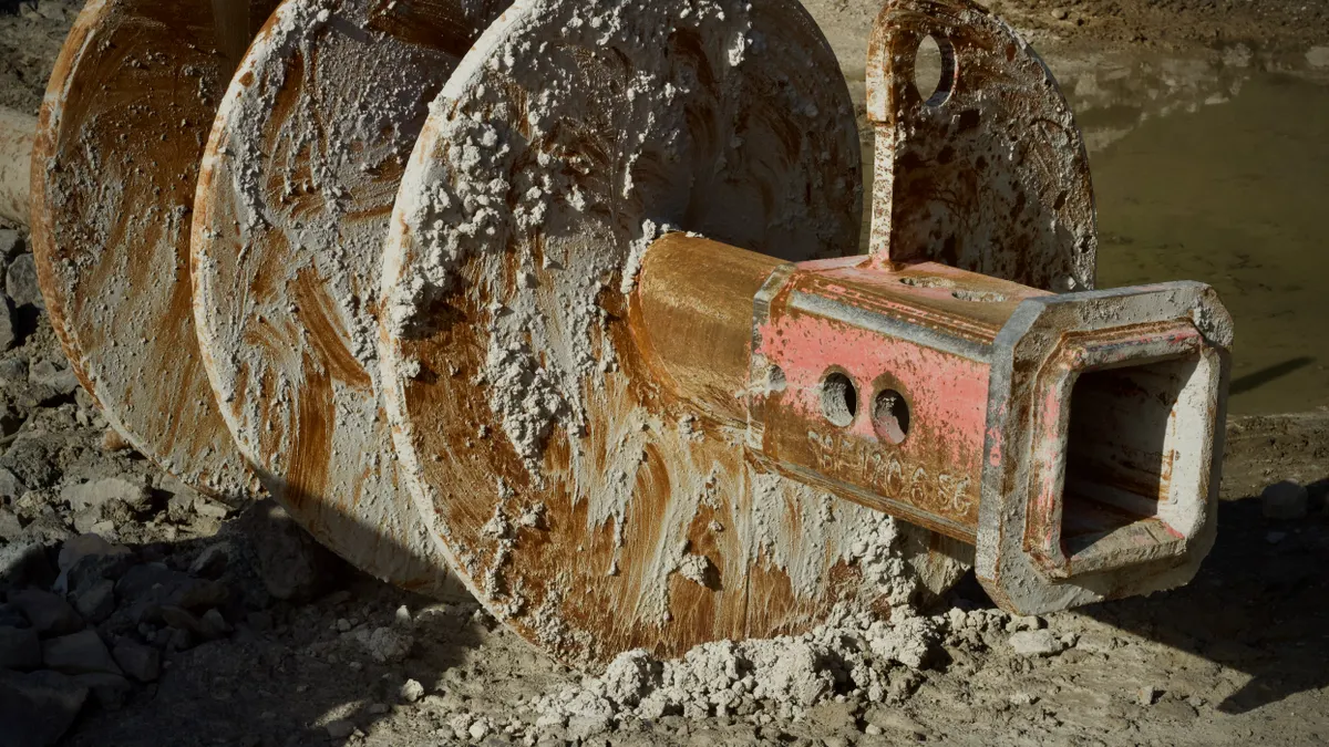 Mud-covered auger drill bit from foundation work