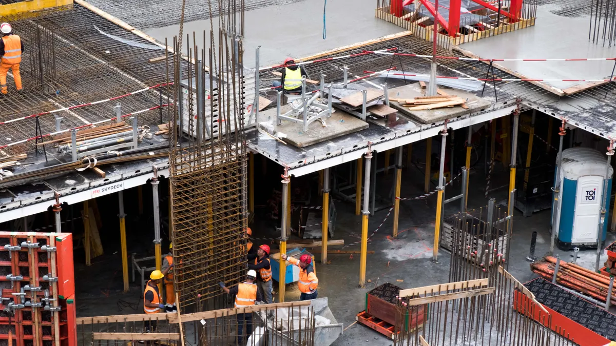 Large foundation excavation with rebar and workers