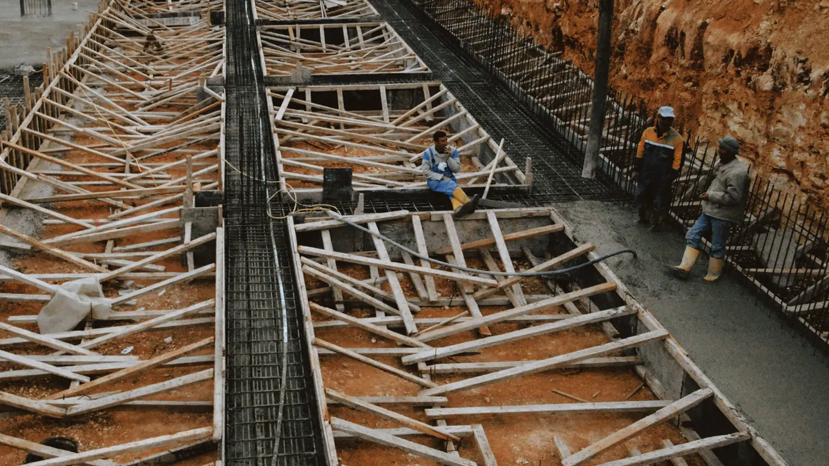 Foundation pit with timber formwork and workers
