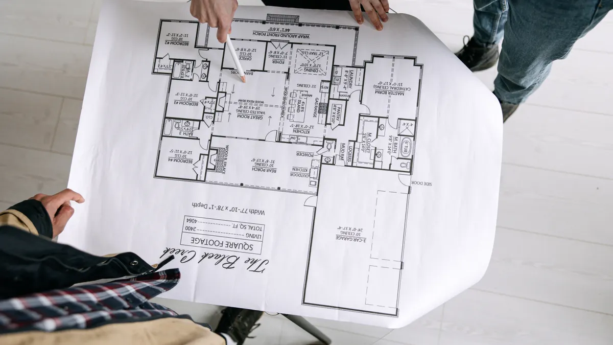 Preconstruction planning and site readiness — The Complete Guide hands pointing at an architectural floor plan