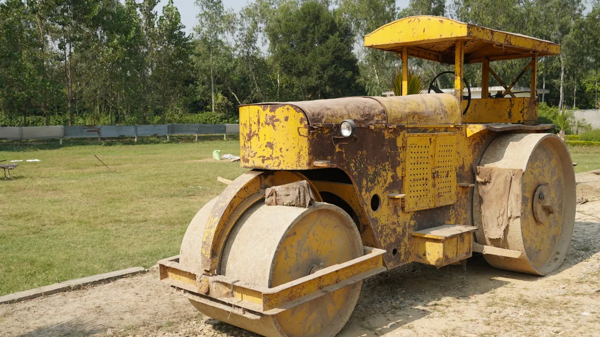 Road roller compacting a dirt surface
