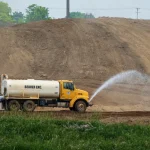 water truck spraying soil at a construction site